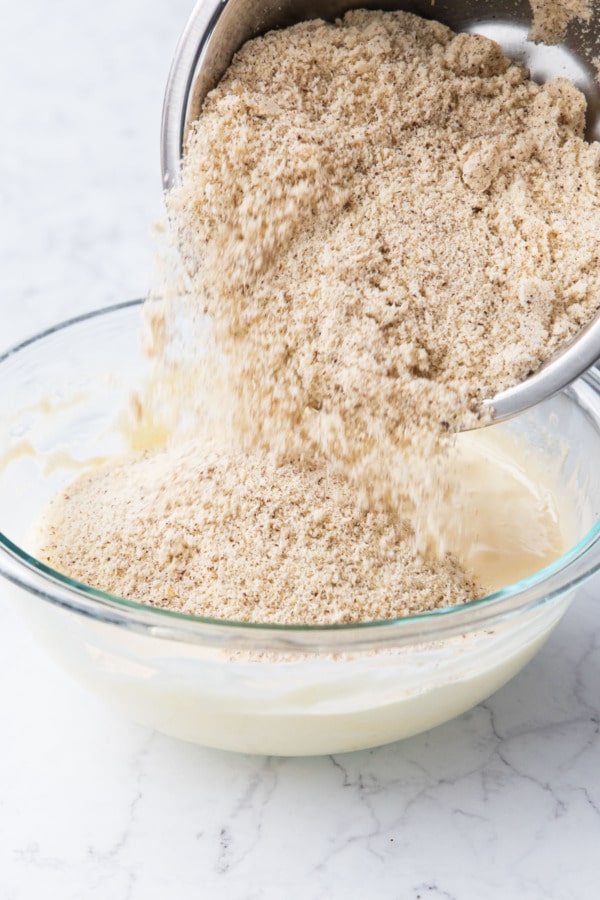 Pouring half of the hazelnut flour into mixing bowl.