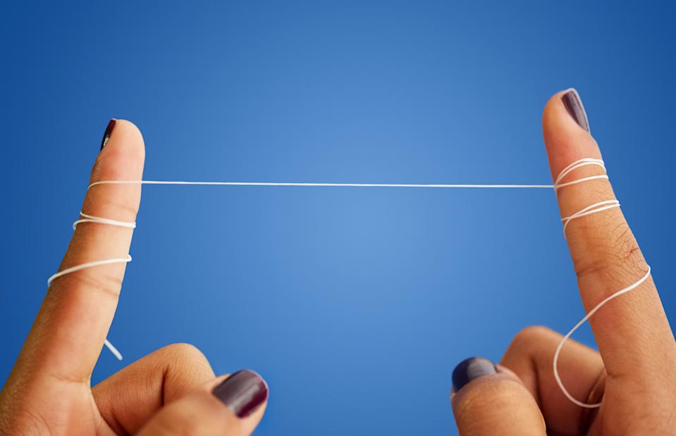 Fingers wrapped with dental floss, demonstrating a technique for effective flossing