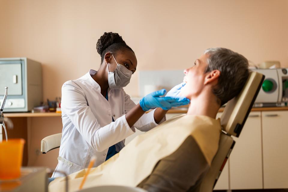 Dentist examines a smiling patient in a dental office, promoting oral health care