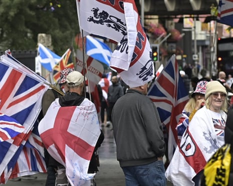 People carrying flags and banners gather in London for a march organised by far-right activist Tommy Robinson.