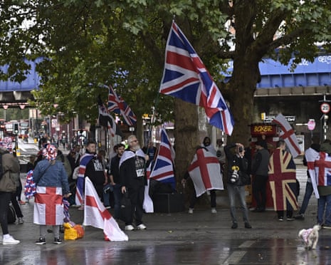 People carrying flags and banners gather in London for a march organised by far-right activist Tommy Robinson.