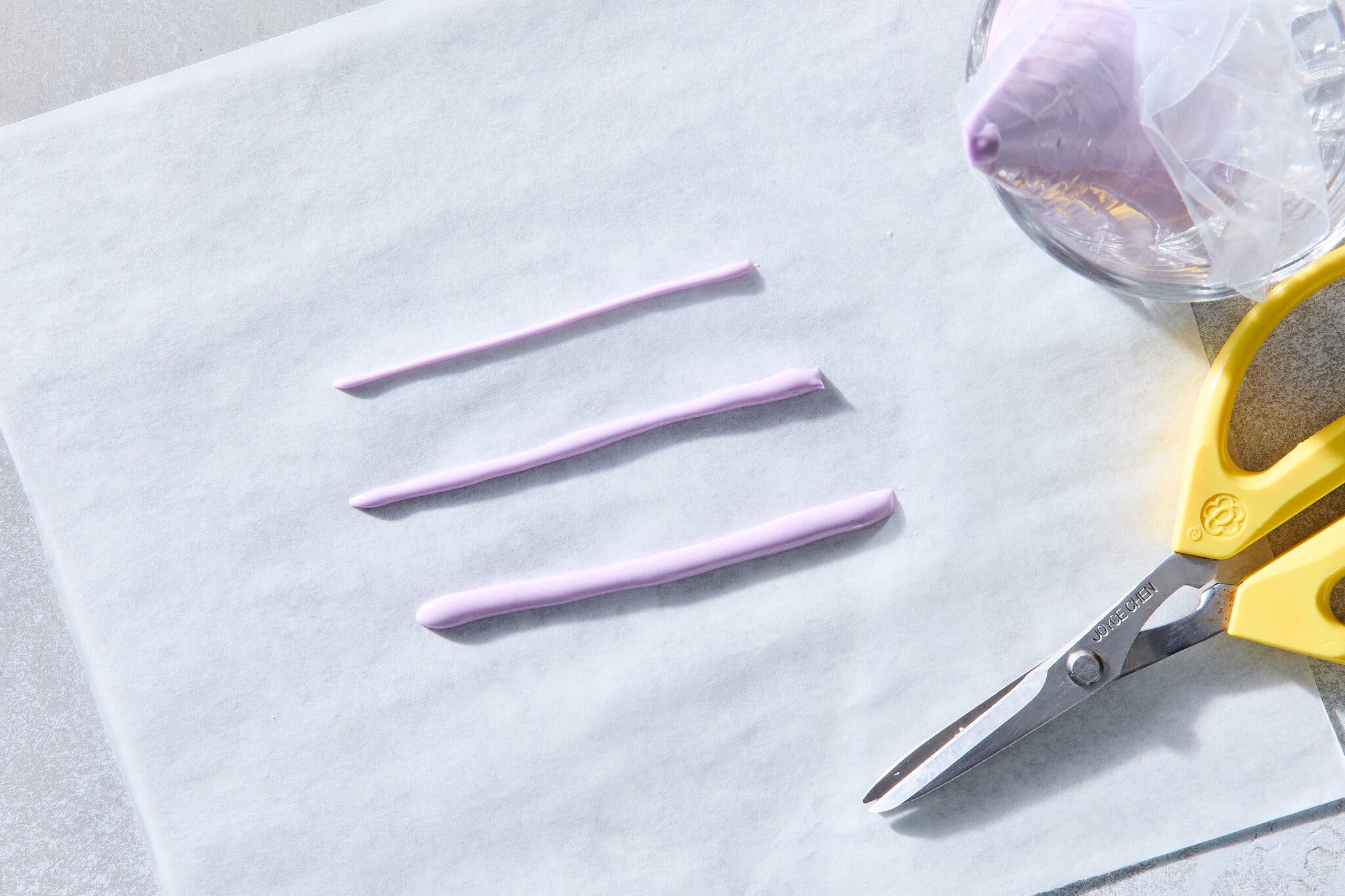 An overhead image of three piped lines of various thicknesses on a piece of parchment.